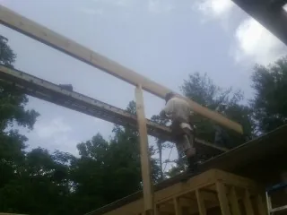 Carpenter setting a ridge beam over a new addition frame — Ice Dam Removal by Roofing Brothers in Dallas Center