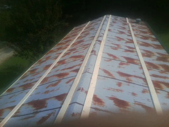 Rusted metal roof panels with new wood purlins before replacement — Storm Damage Roof Repair in Dallas Center by Roofing Brothers