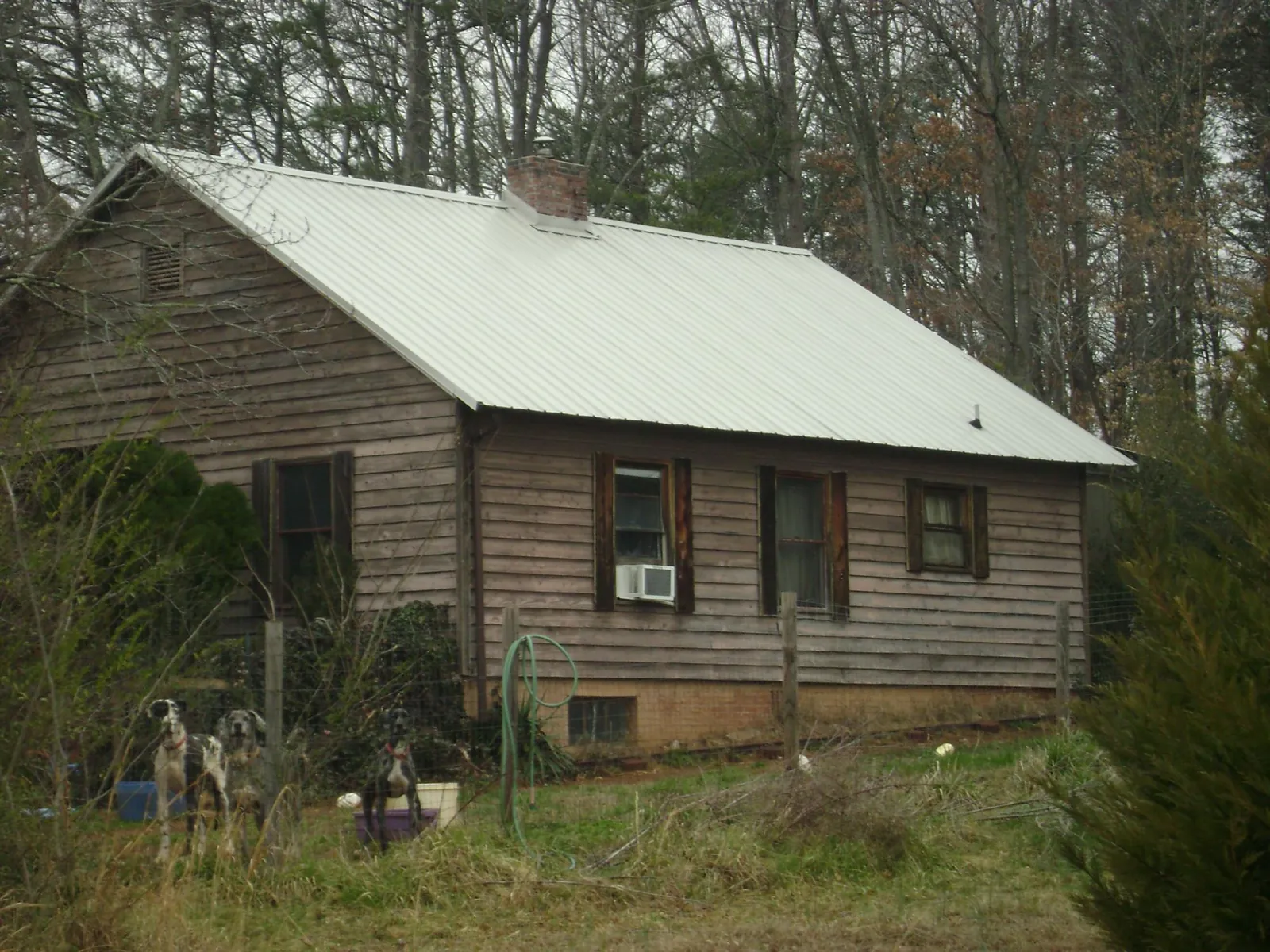 White metal roof on an old wood sided farmhouse, from a Metal Roof Installation job in Dallas Center